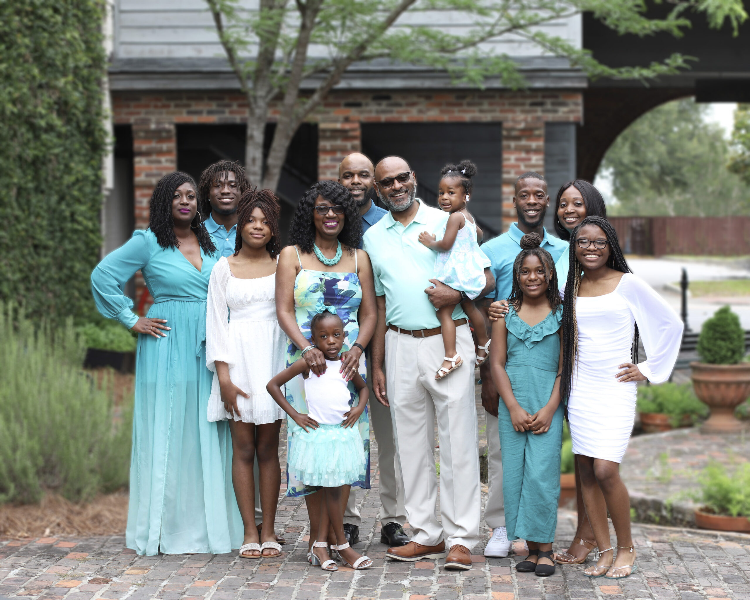 Large Family dressed in blues, whites, and teals happy and smiling